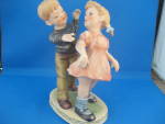 I have had more people pick this figurine up thinking it is a Hummell piece.  Wonderful figurine of a boy and girl that is 7 1/2" tall.  Has a foil sitcker on the bottom that says, "Wales, M...