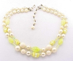 This is a vintage two strand choker necklace signed JAPAN.  The necklace has yellow foil art glass beads, yellow crackled glass beads, yellow crystals, and faux pearls.  The necklace is adjustable and...