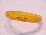 This is a vintage bangle bracelet made of butterscotch bakelite.  The bracelet is not marked but has been tested.  The bracelet has four carved flowers and large X's along the outside.  The bracelet m...