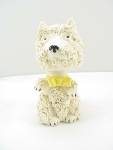 This is a vintage ceramic figurine signed JAPAN.  It is a spaghetti dog with a nodder or bobble head.  The dog looks more like a terrier but it might be a poodle.  It is wearing a yellow bow around it...