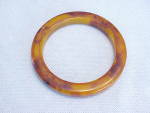 This is a marbled butterscotch or tortoiseshell bakelite bracelet. It has been tested with Simichrome. The bracelet measures 3-1/4 inches in diameter and is 1/4 of an inch wide. It is in very good con...