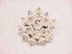 This is a vintage brooch signed JAPAN.  It has white glass flowers with aurora borealis crystals in the center.  The brooch measures 1-1/2 inches in diameter.  The brooch is in good condition but may ...